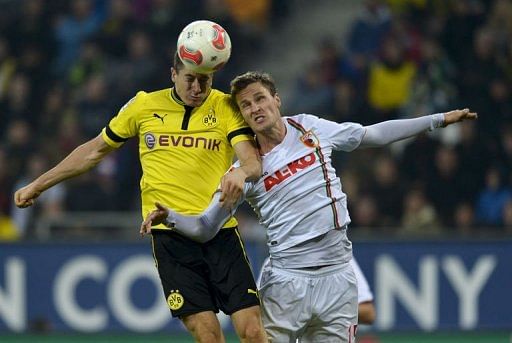 FC Augsburg's defender Sebastian Langkamp (R) and Dortmund's striker Robert Lewandowski jump for the ball